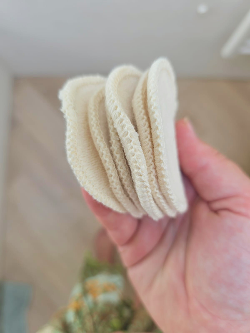Meerdere wasbare katoenen schijfjes naast elkaar in een hand